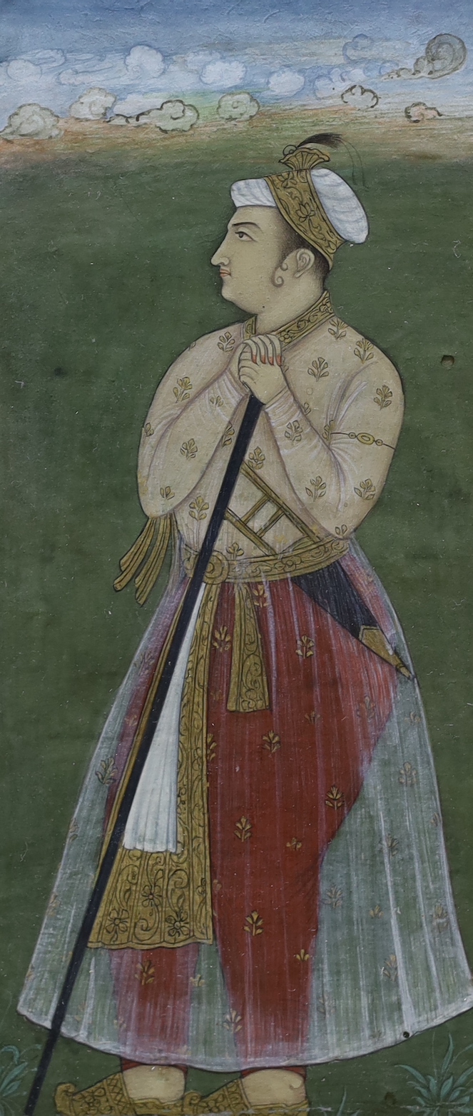 Indian School, gouache and watercolour heightened with gilt, Full length portrait of a dignitary standing holding a staff, Mughal style, 15.5 x 7cm